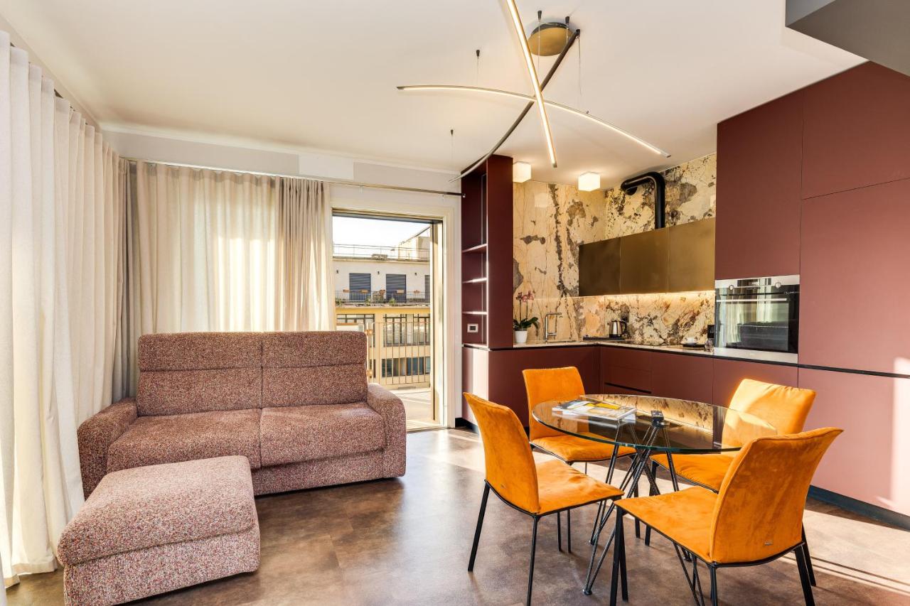 een woonkamer met een bank, een tafel en stoelen bij Gasometer Urban Suites in Rome