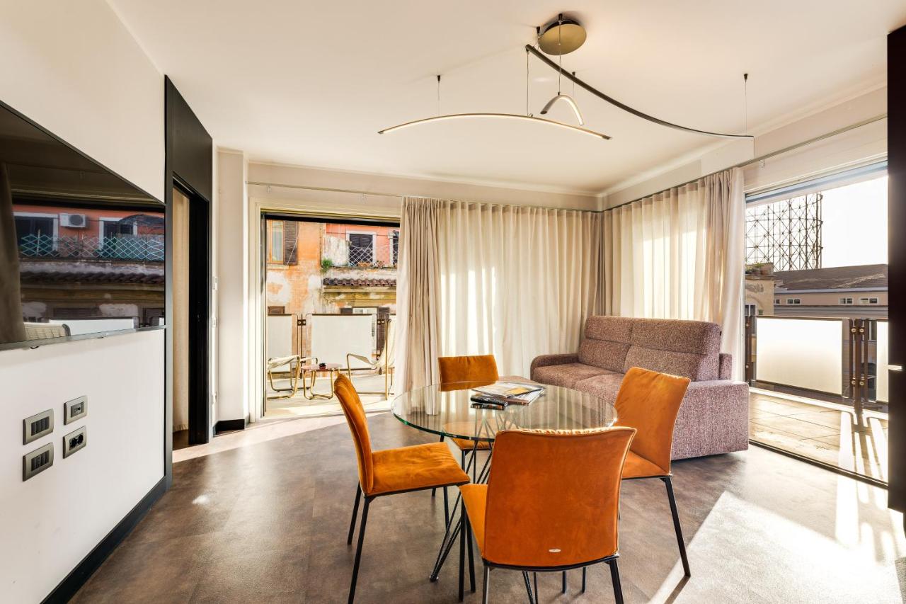 een woonkamer met een bank, een tafel en stoelen bij Gasometer Urban Suites in Rome