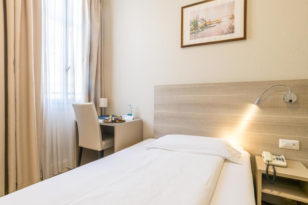 een hotelkamer met een bed en een bureau bij Hotel Bazzoni in Tremezzo