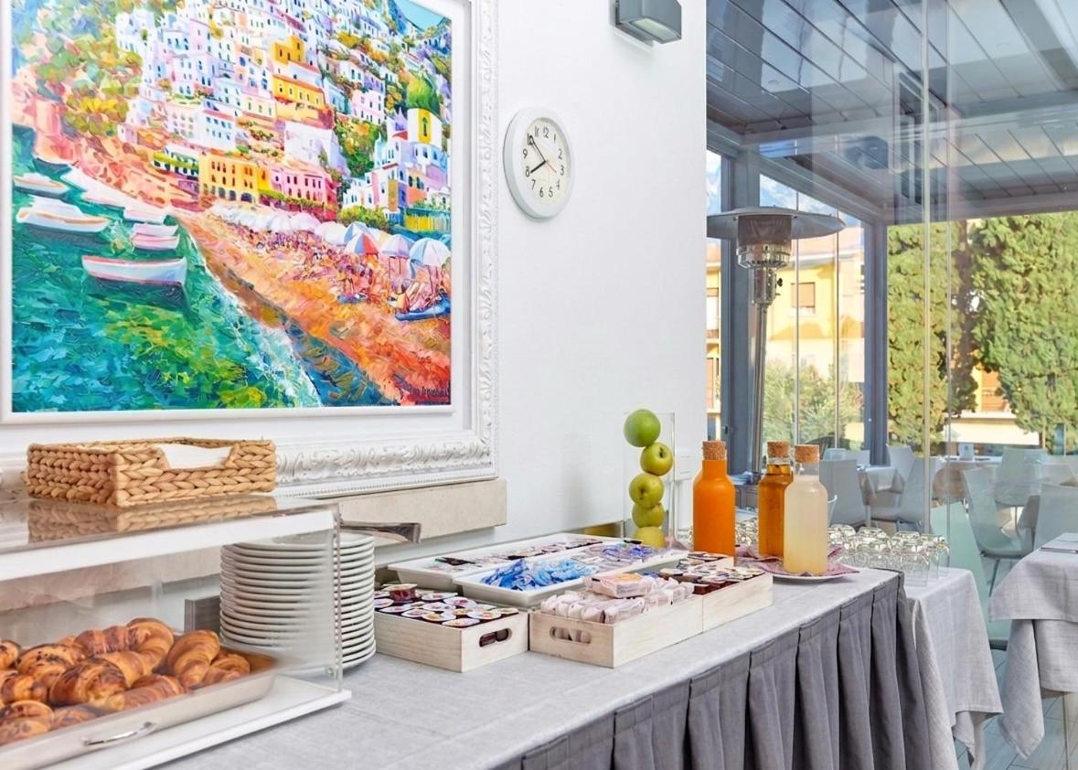 een tafel met eten en een schilderij aan de muur bij Hotel Geier in Nago-Torbole