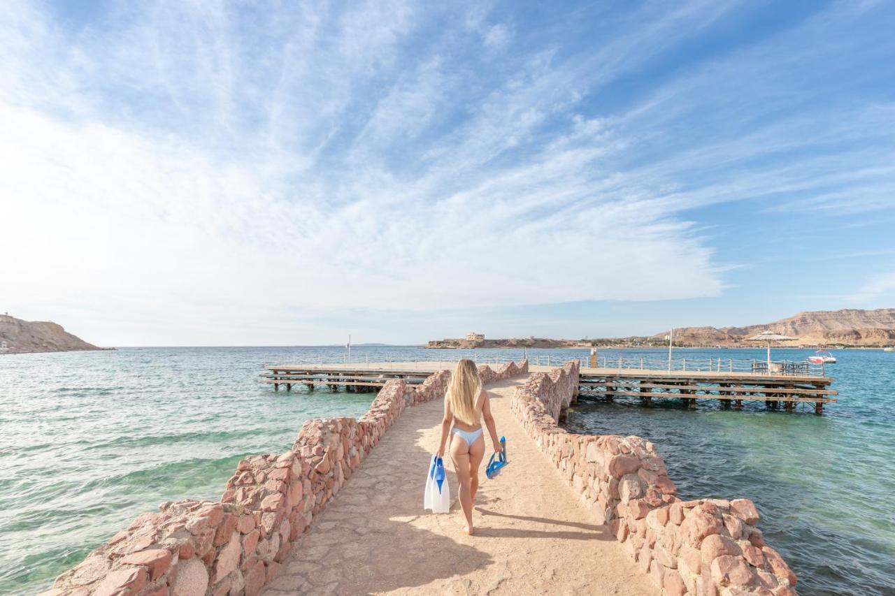 een vrouw die langs een muur op het strand loopt bij Albatros Sharm Resort - By Pickalbatros in Sharm El Sheikh