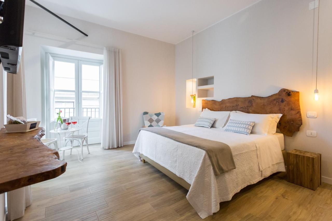 een witte slaapkamer met een groot bed en een raam bij Bellaroto Suite & Spa - Charming Boutique Rooms in Palermo