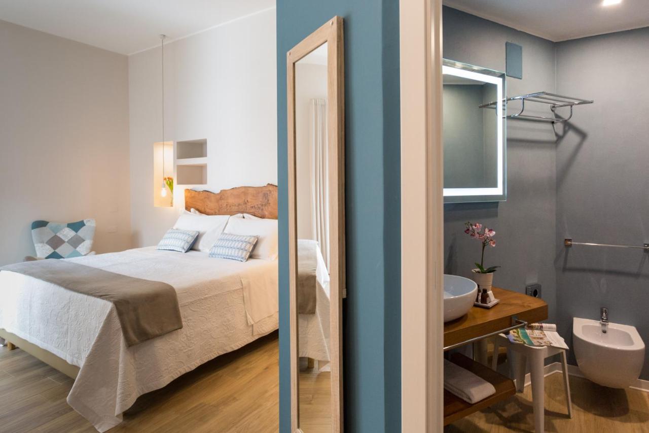een slaapkamer met een bed en een badkamer met een wastafel bij Bellaroto Suite & Spa - Charming Boutique Rooms in Paler