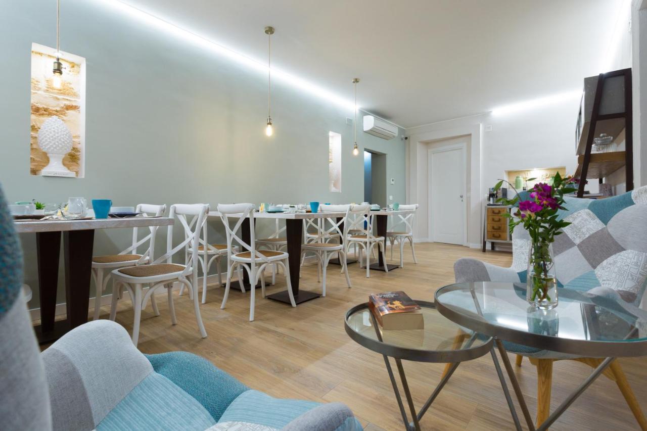 een woonkamer met een tafel en stoelen bij Bellaroto Suite & Spa - Charming Boutique Rooms in Palermo