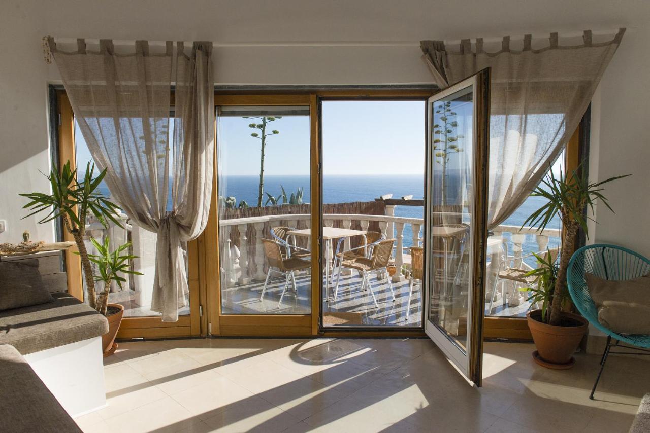 een woonkamer met uitzicht op de oceaan bij Laneez Ericeira Surf House in Ericeira