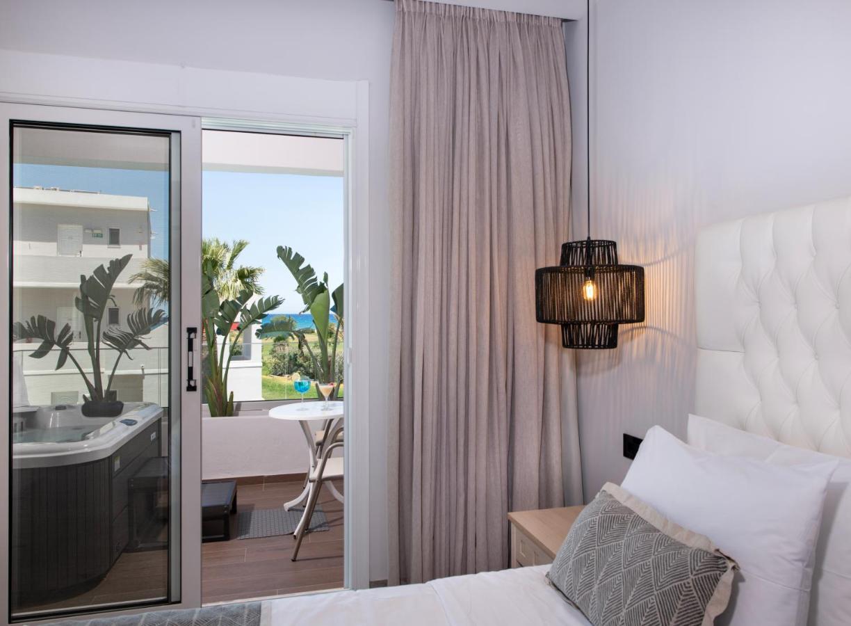 een slaapkamer met een bed en uitzicht op een badkamer bij Delfina Tropic Beach - Adults Only in Georgioupolis