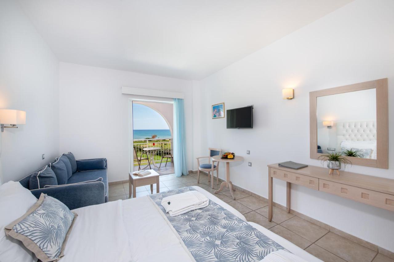 een woonkamer met een bed en een spiegel bij Delfina Tropic Beach - Adults Only in Georgioupolis