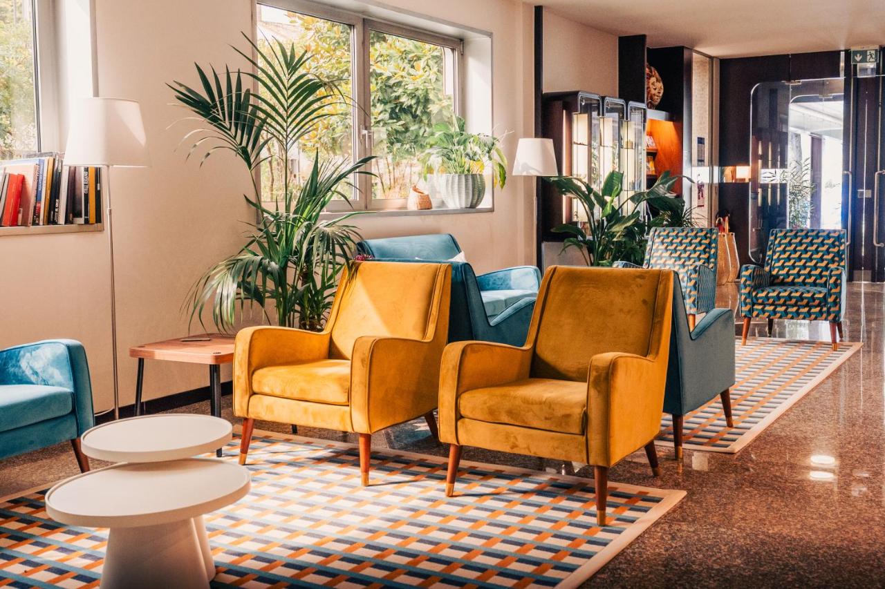 een wachtkamer met stoelen, tafels en planten bij Garden Hotel Michelangelo in Mestre