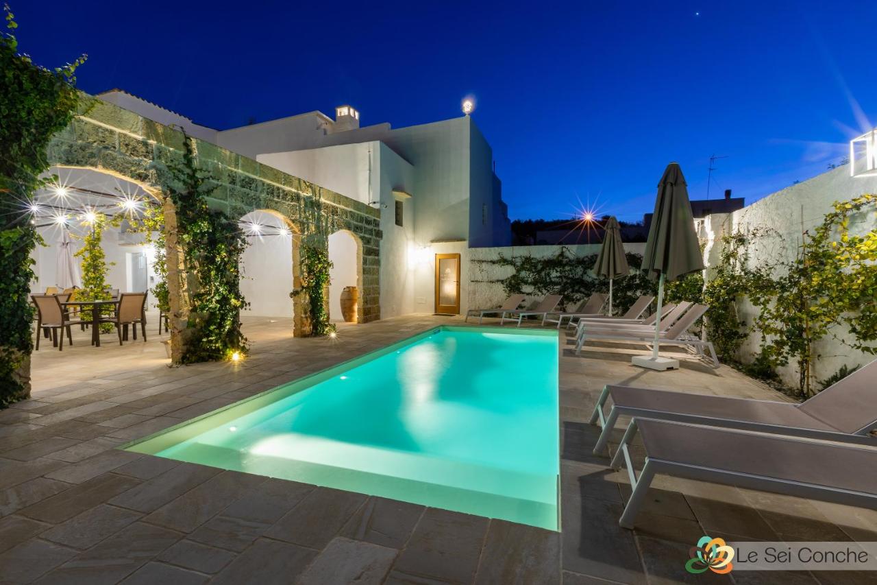 een villa met een zwembad 's nachts bij Le Sei Conche Relais & SPA in Gemini