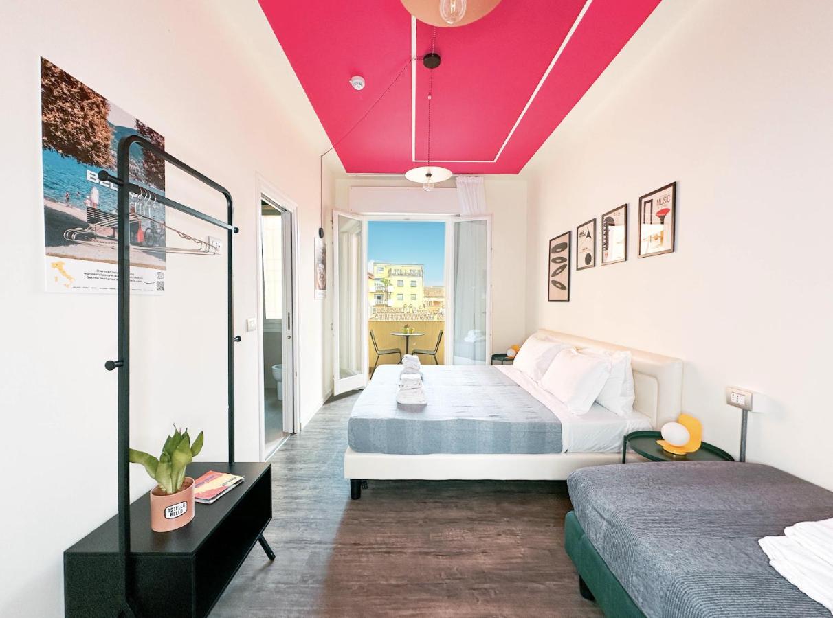 een kamer met twee bedden en een rood plafond bij Ostello Bello Bologna in Bologna