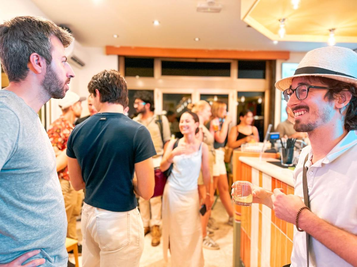 een groep mensen die rond een bar staan bij Ostello Bello Bologna in Bologna