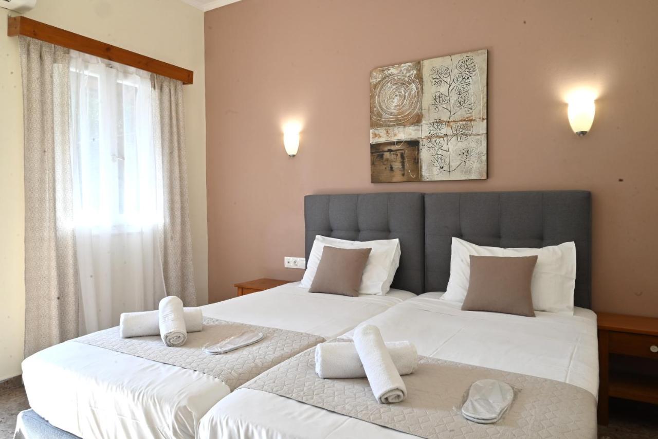 een slaapkamer met twee bedden waarop witte handdoeken liggen bij Gina Studios in Benitses