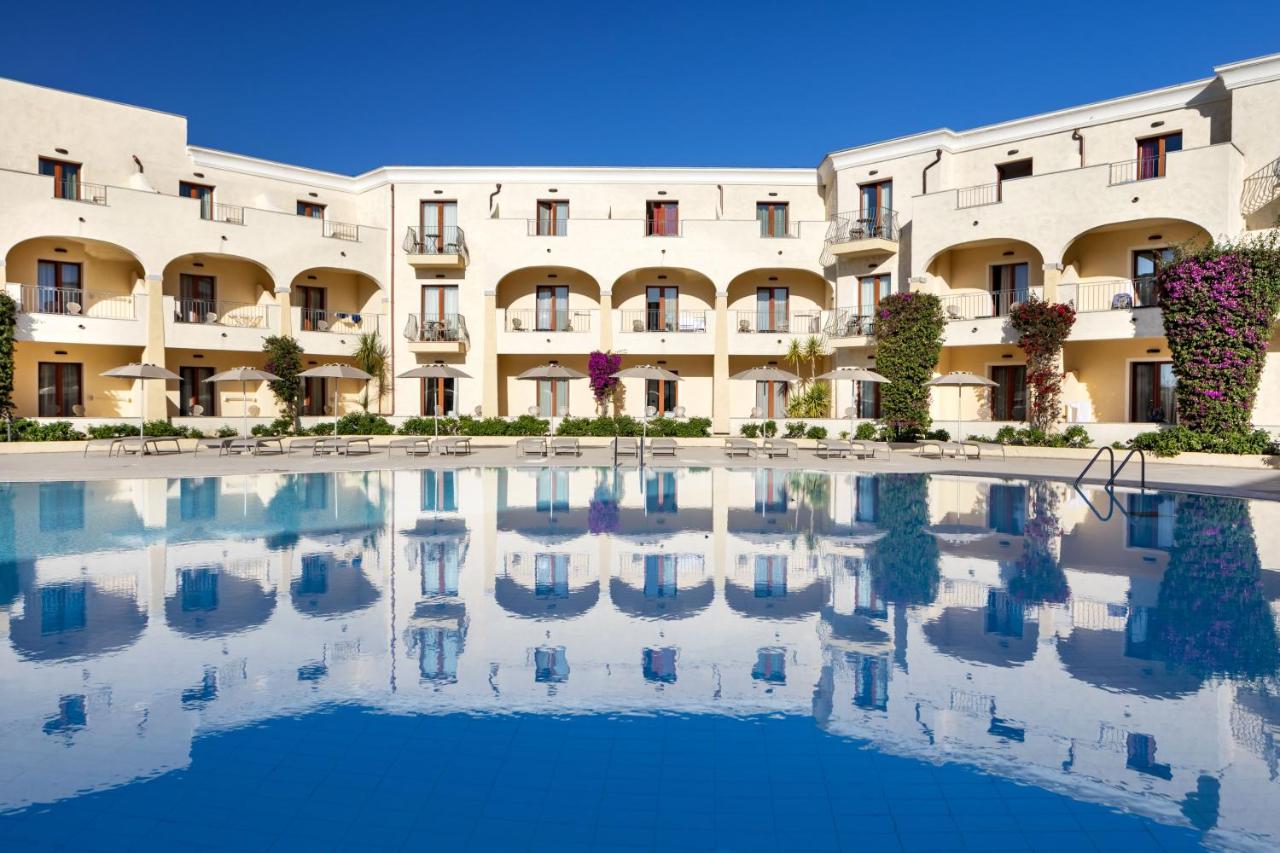 een gebouw met een zwembad ervoor bij Blu Hotel Morisco in Cannigione