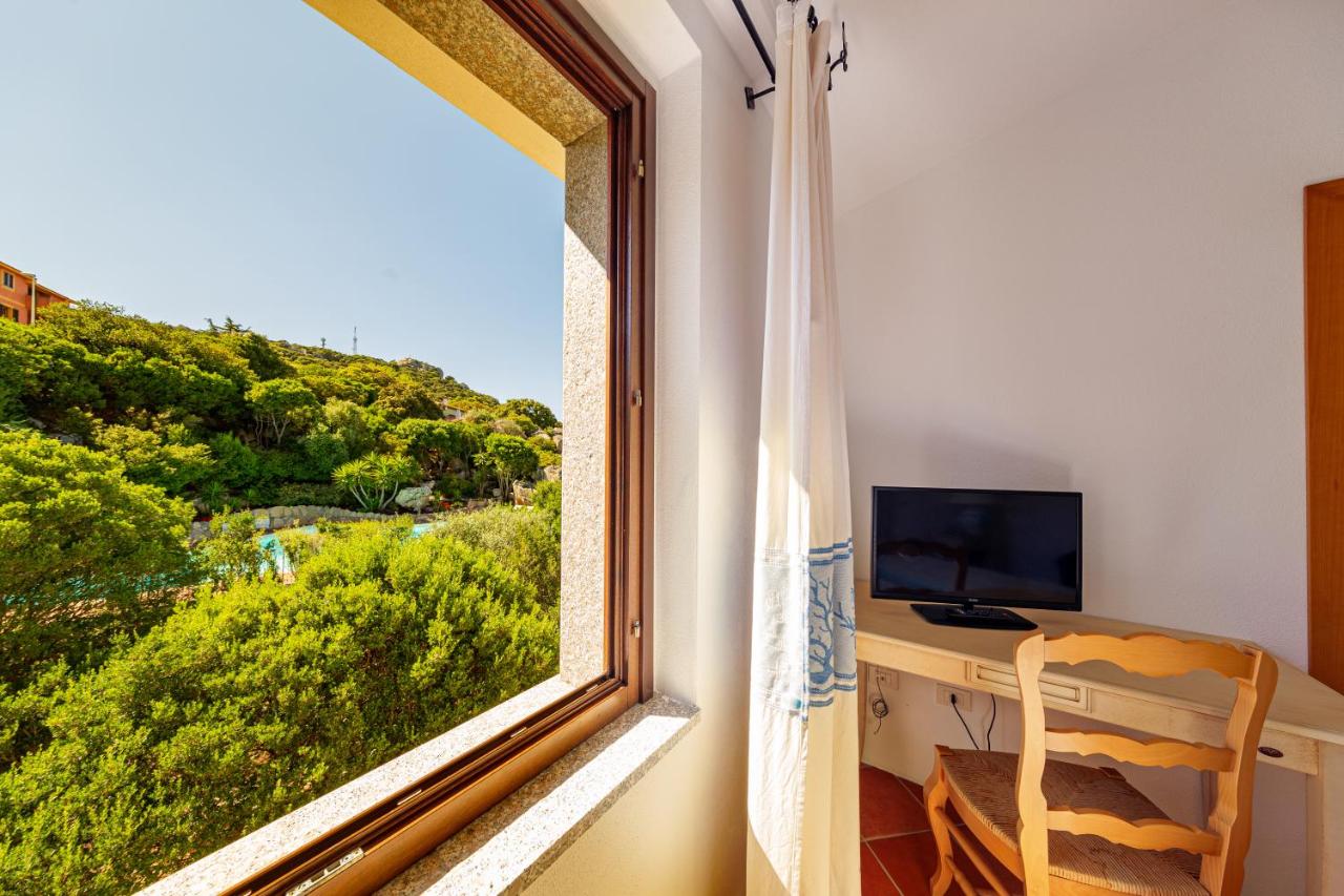 een kamer met een raam, een bureau en een televisie bij Hotel San Trano in Luogosanto