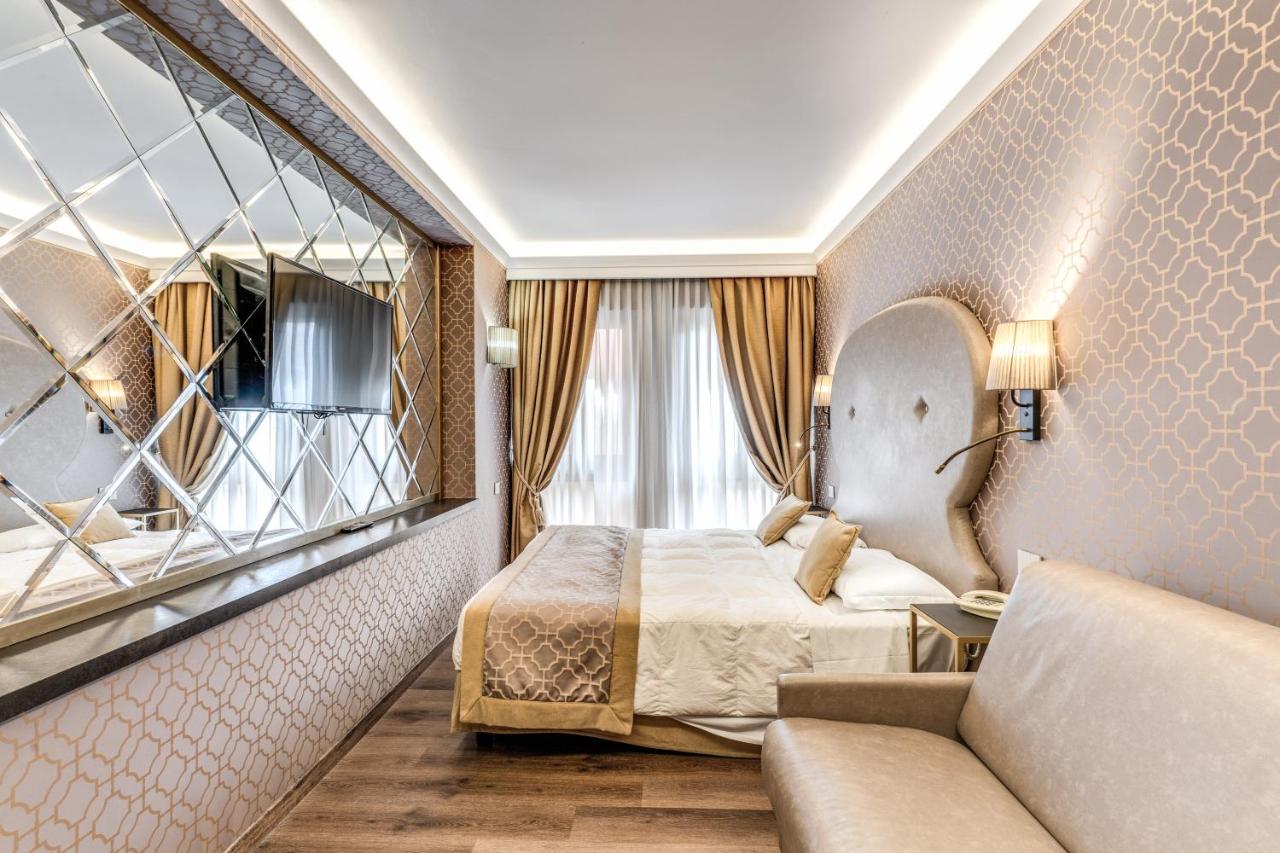 een hotelkamer met een bed en een bank bij Hotel Belle Arti in Venetië