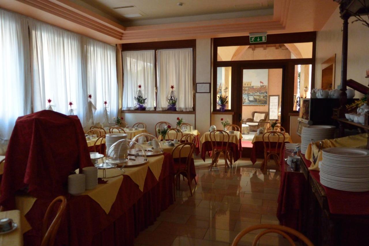 een eetzaal met tafels en stoelen in een restaurant bij Hotel Belle Arti in Venetië