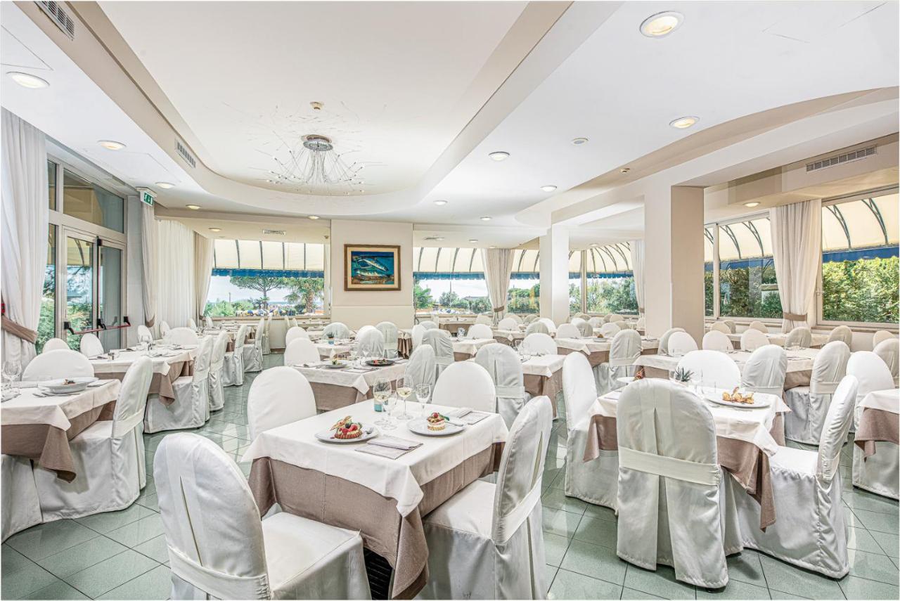 een feestzaal met witte tafels en stoelen bij Hotel Bellevue in Bibione