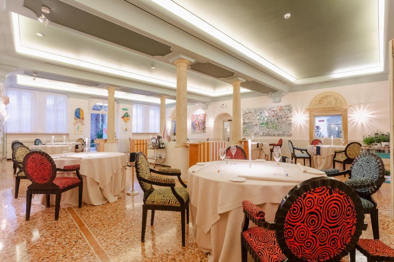 een eetkamer met twee tafels en stoelen bij Byblos Art Hotel Villa Amistà in San Pietro in Cariano