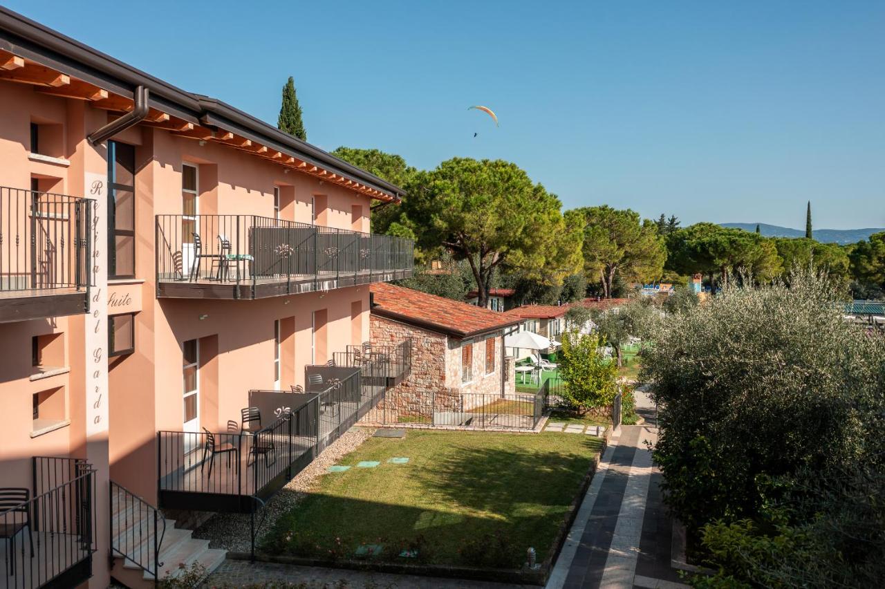 een appartementencomplex met balkons en een tuin bij Regina del Garda Suite in Toscolano Maderno