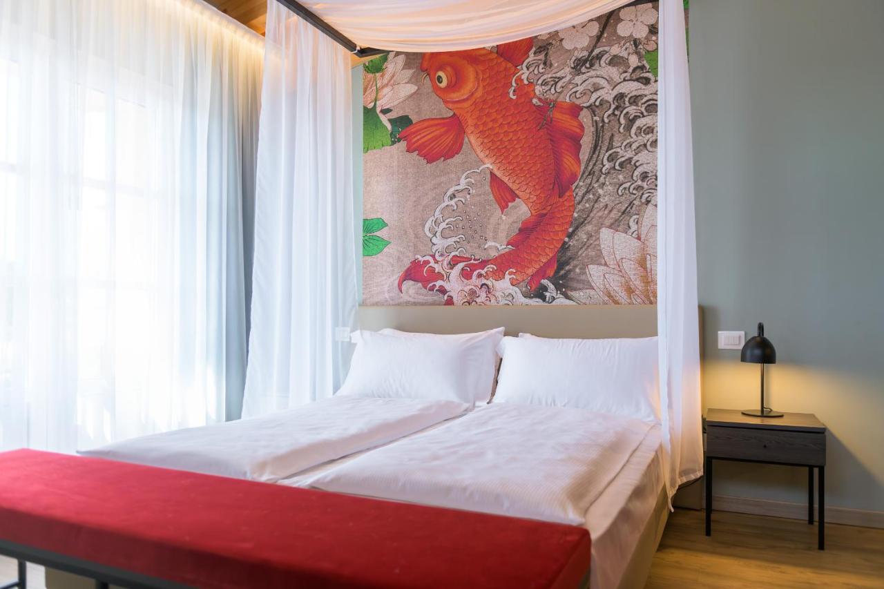 een slaapkamer met een bed en een poster aan de muur bij Regina del Garda Suite in Toscolano Maderno
