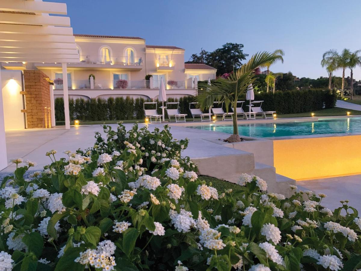 een villa met een zwembad en bloemen bij Il Borghetto Resort & Spa in Tropea