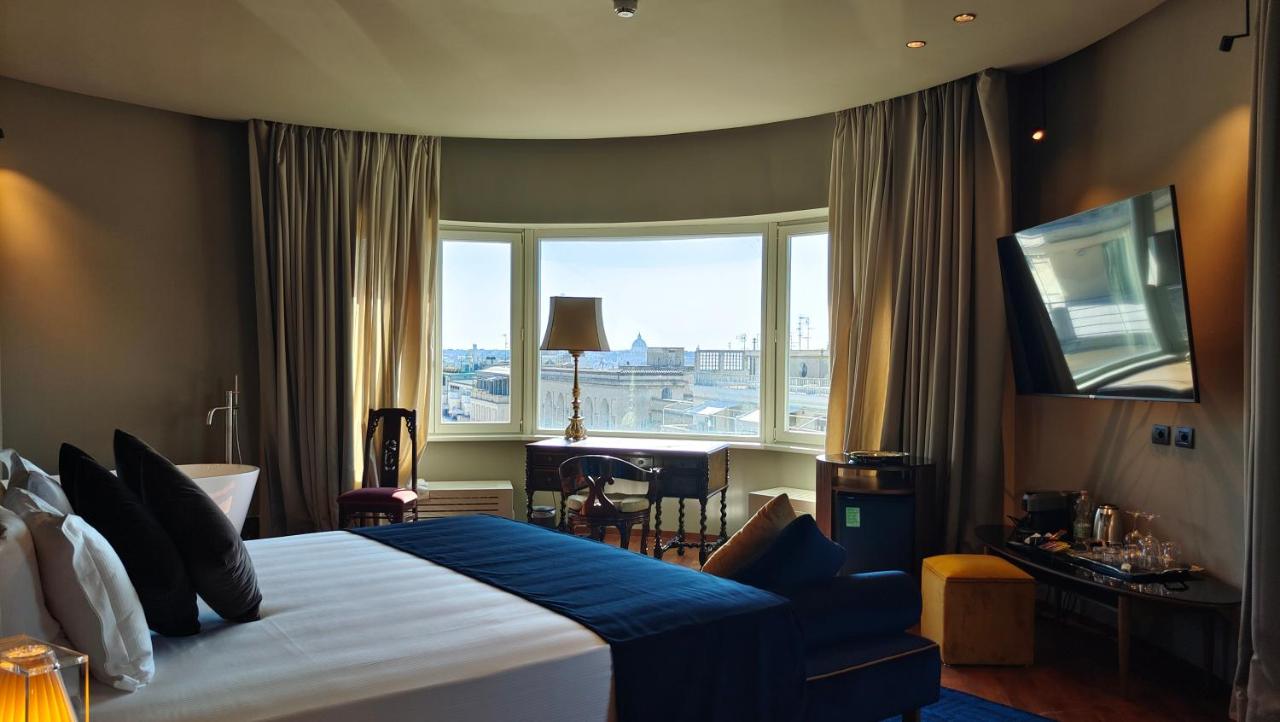 een hotelkamer met een groot bed en een groot raam bij Triviho Hotel in Rome