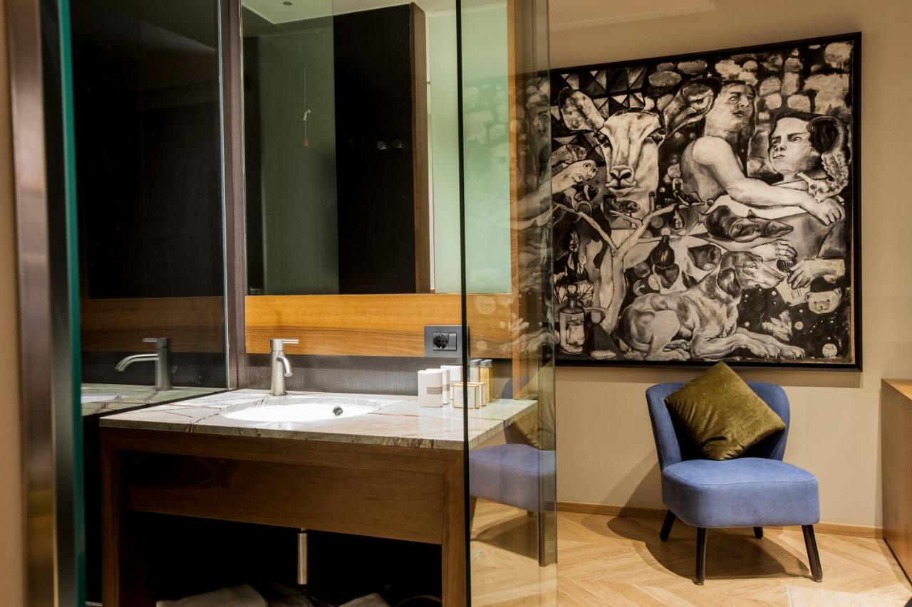 een badkamer met een wastafel, een spiegel en een stoel bij Triviho Hotel in Rome