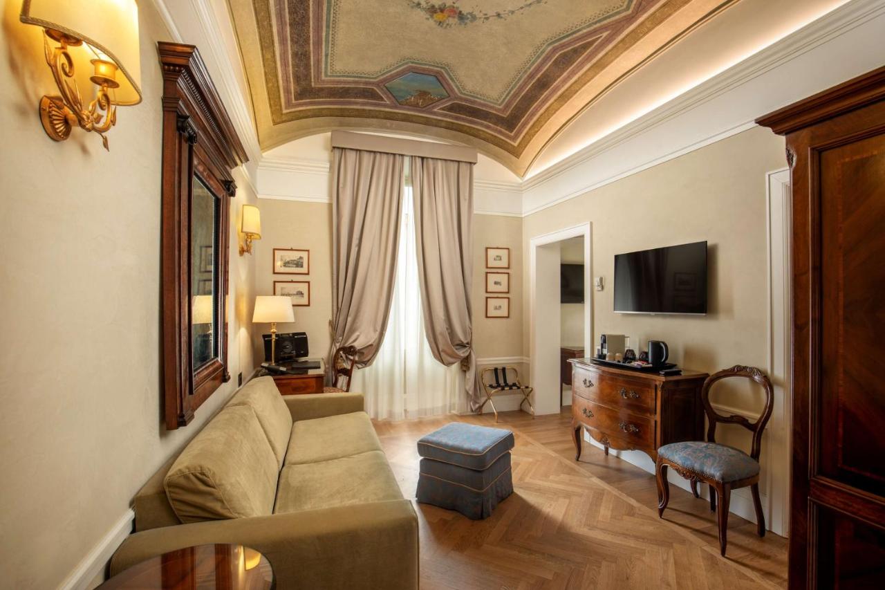 een woonkamer met een bank en een tv bij Hotel Canada, BW Premier Collection in Rome