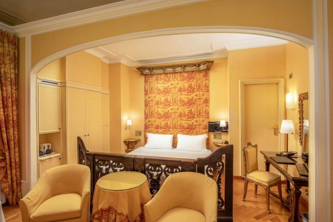 een slaapkamer met een bed, een bureau en stoelen bij Hotel Canada, BW Premier Collection in Rome