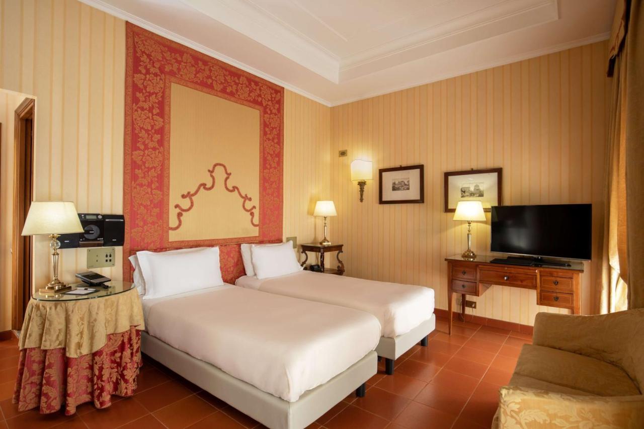 een hotelkamer met twee bedden en een televisie bij Hotel Canada, BW Premier Collection in Rome