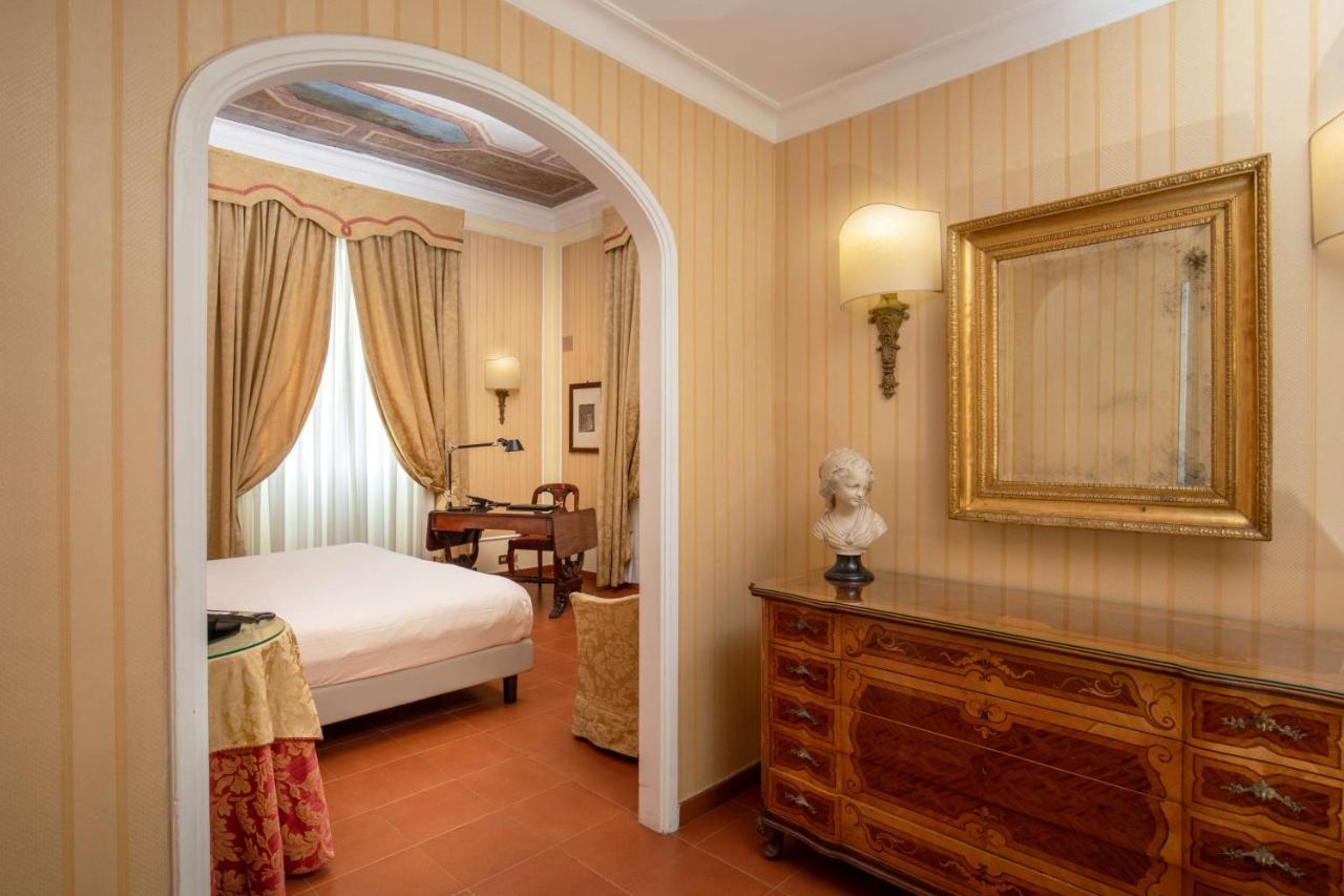 een slaapkamer met een bed, een spiegel en een tafel bij Hotel Canada, BW Premier Collection in Rome