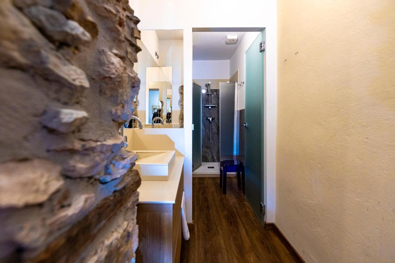 een badkamer met een stenen muur naast een wastafel bij Hotel Corona in Spiazzi Di Caprino