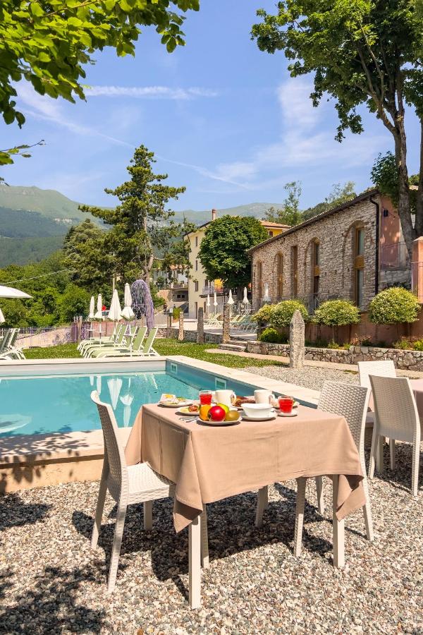 een tafel en stoelen naast een zwembad bij Hotel Corona in Spiazzi Di Caprino