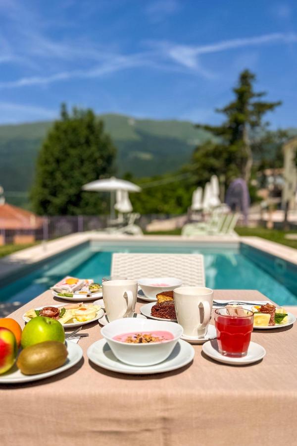 een tafel met borden eten naast een zwembad bij Hotel Corona in Spiazzi Di Caprino