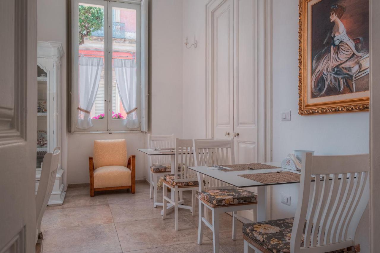 een eetkamer met tafels en stoelen en een schilderij aan de muur bij Relais Palazzo Vaglio in Nardò