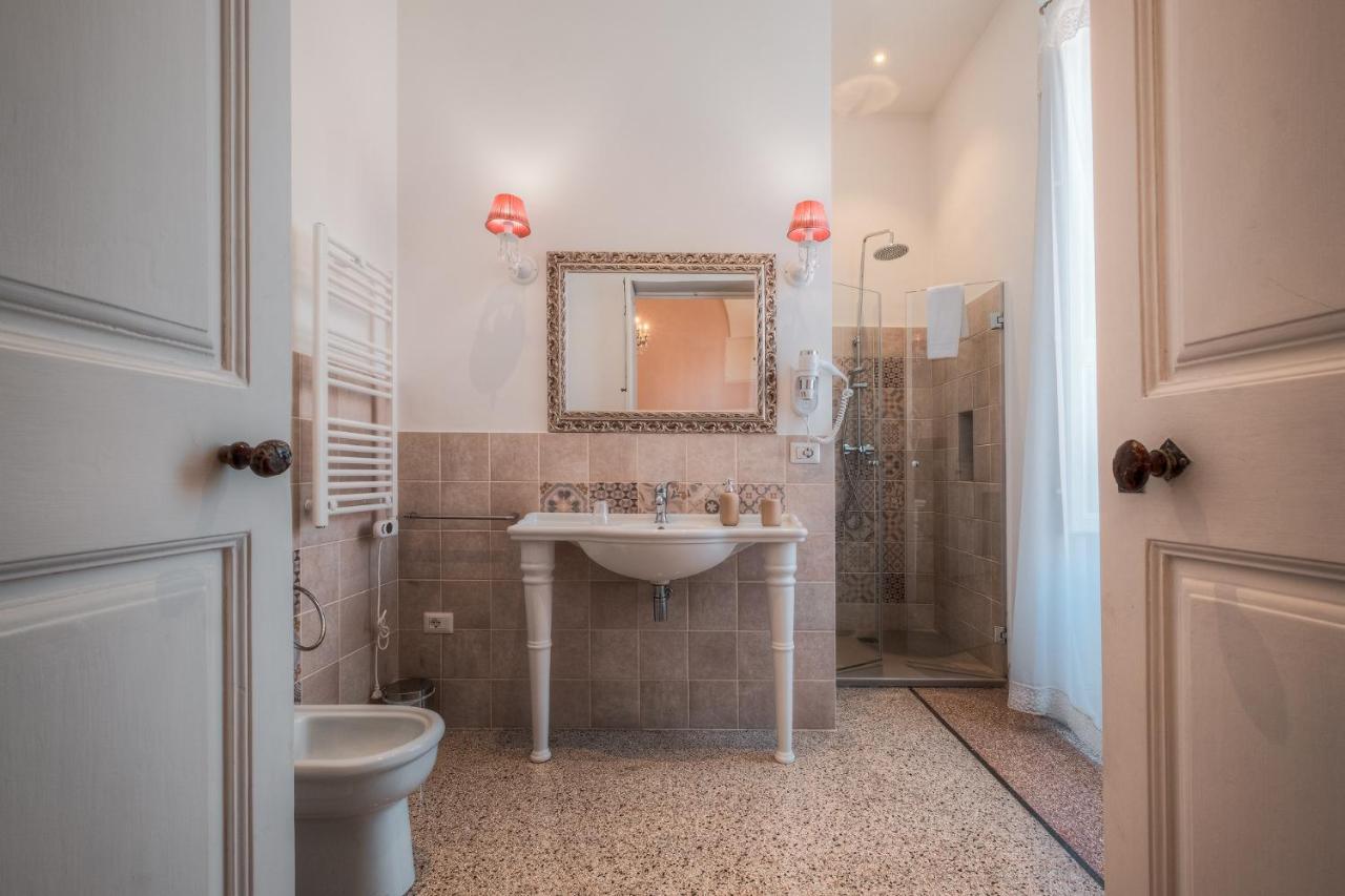 een badkamer met een wastafel, een toilet en een spiegel bij Relais Palazzo Vaglio in Nardò +76 foto's