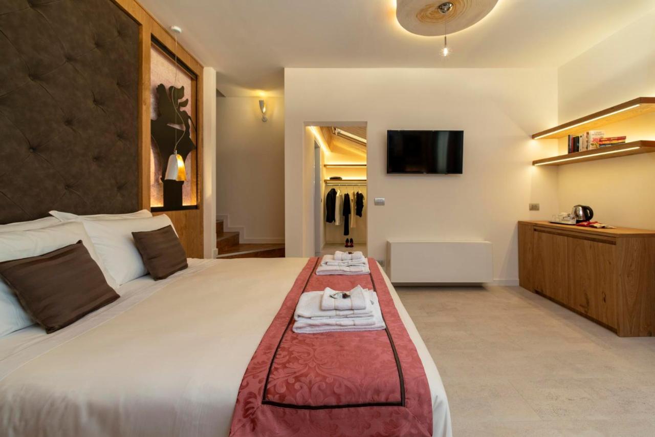 een hotelkamer met een groot bed en een tv bij Ca' de la Fonte - WENICE Deep Culture in Venetië