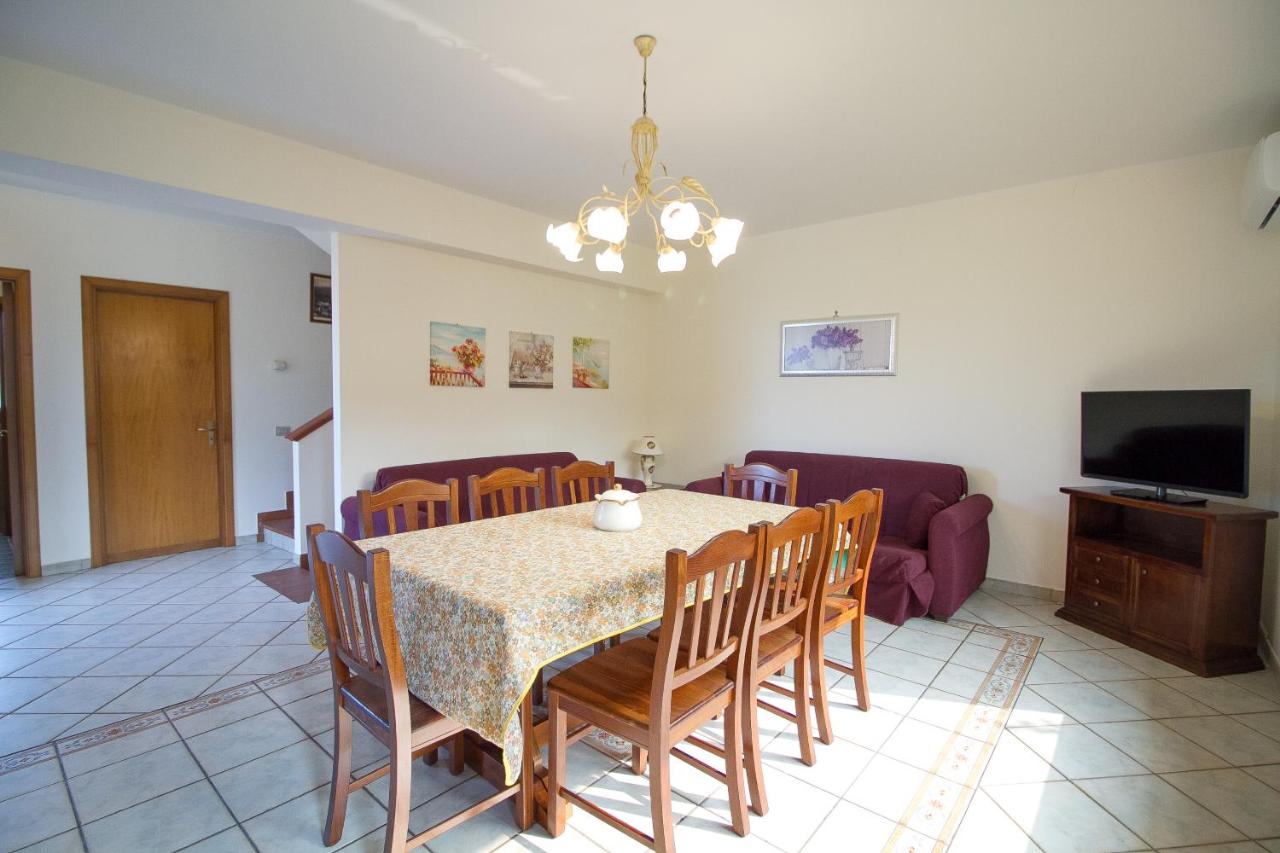 een eetkamer met een tafel en stoelen en een tv bij Etna Villa Alba Chiara in Trecastagni