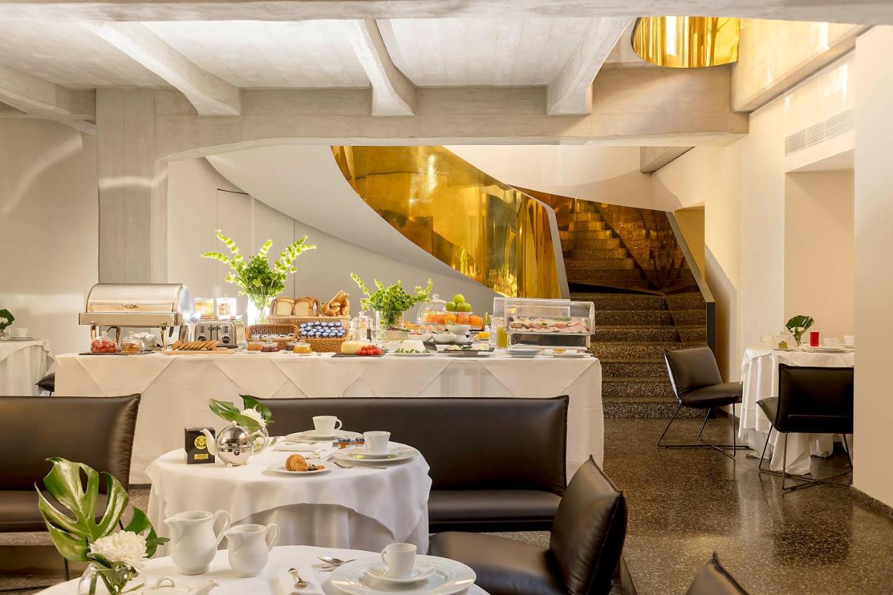 een restaurant met witte tafels en stoelen en een trap bij Hotel Royal Bissolati in Rome