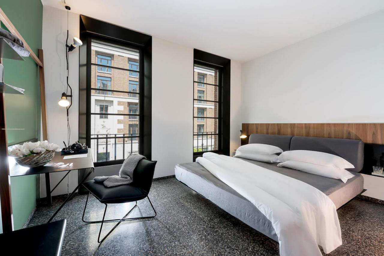 een slaapkamer met een groot bed en een stoel bij Hotel Royal Bissolati in Rome