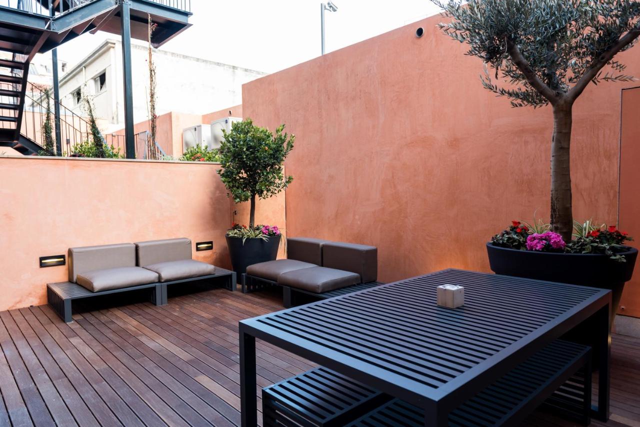 een terras met een tafel en stoelen op een vlonder bij Flora Chiado Apartments in Lissabon