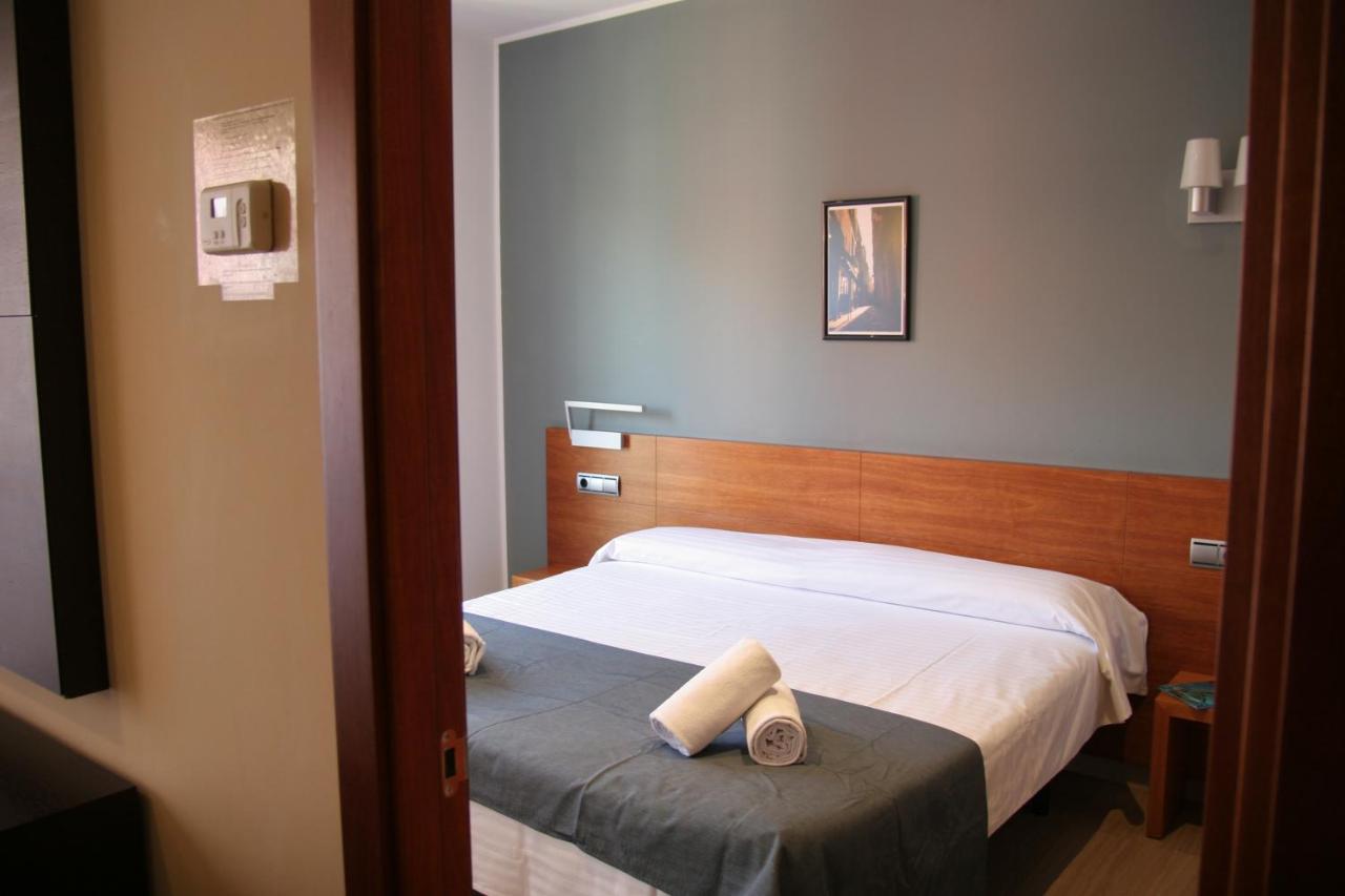een slaapkamer met een bed waarop twee handdoeken liggen bij Apartaments Independencia in Barcelona