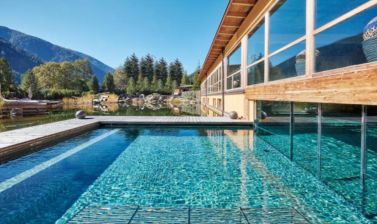 een huis met een zwembad naast een gebouw bij Arosea Life Balance Hotel in Santa Valpurga