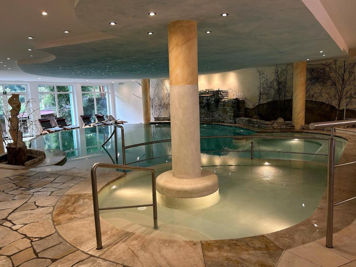 een zwembad met een zuil in een gebouw bij Hotel Bergblick in Racines +62 foto's