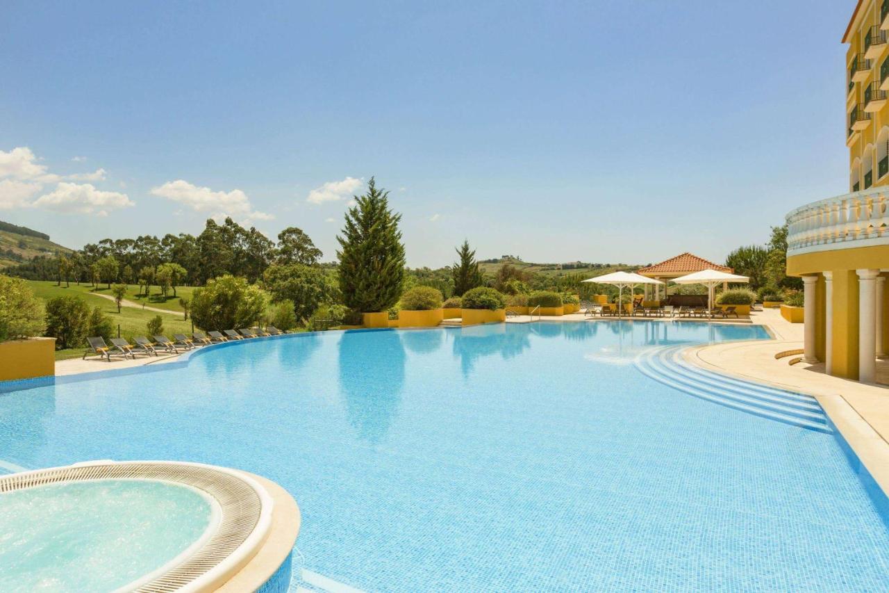 een groot zwembad in een resort met ligstoelen bij Dolce CampoReal Lisboa in Turcifal