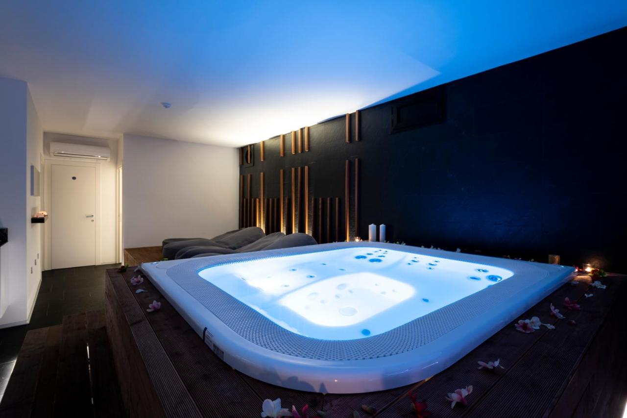 een groot bad in een kamer met een bank bij Alkamuri Posh Hotel e Spa in Alcamo