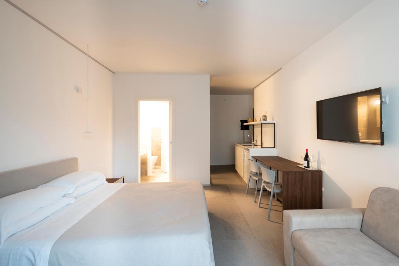 een slaapkamer met een bed, een bureau en een tv bij Alkamuri Posh Hotel e Spa in Alcamo