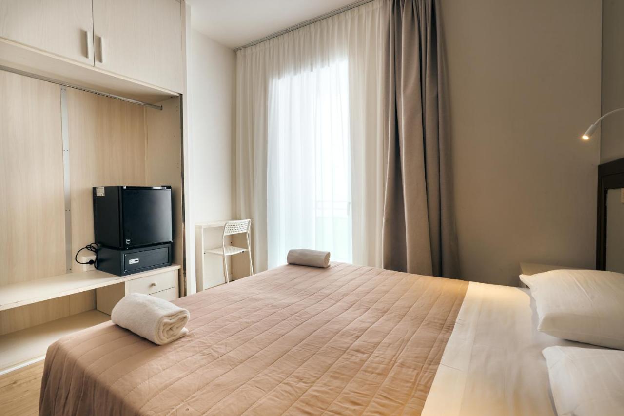 een slaapkamer met een groot bed en een tv erop bij Hotel Bettina in Lido di Jesolo