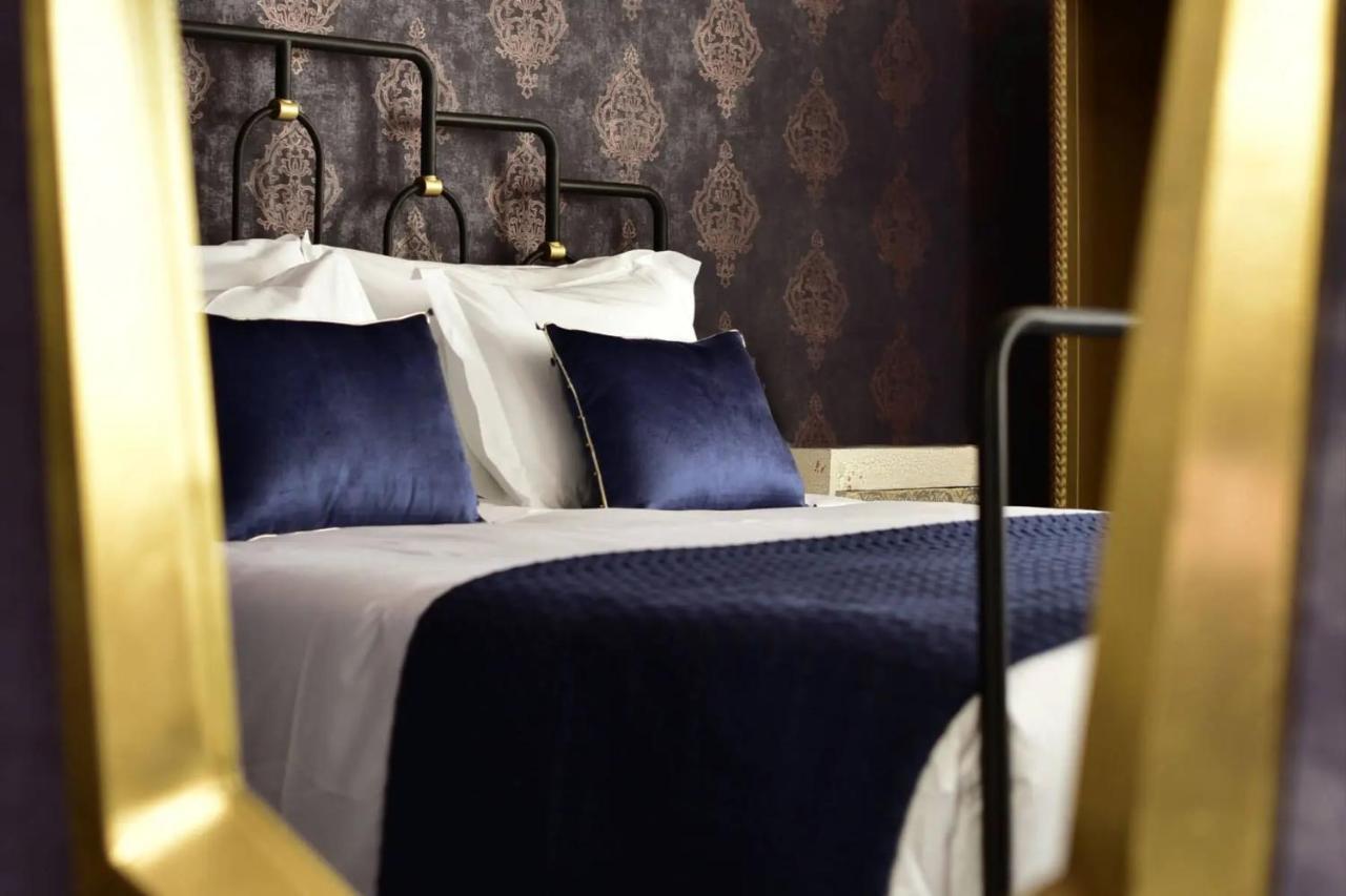 een bed met blauw-witte lakens en kussens bij Maxime Boutique Hotel Avenida da Liberdade in Lissabon