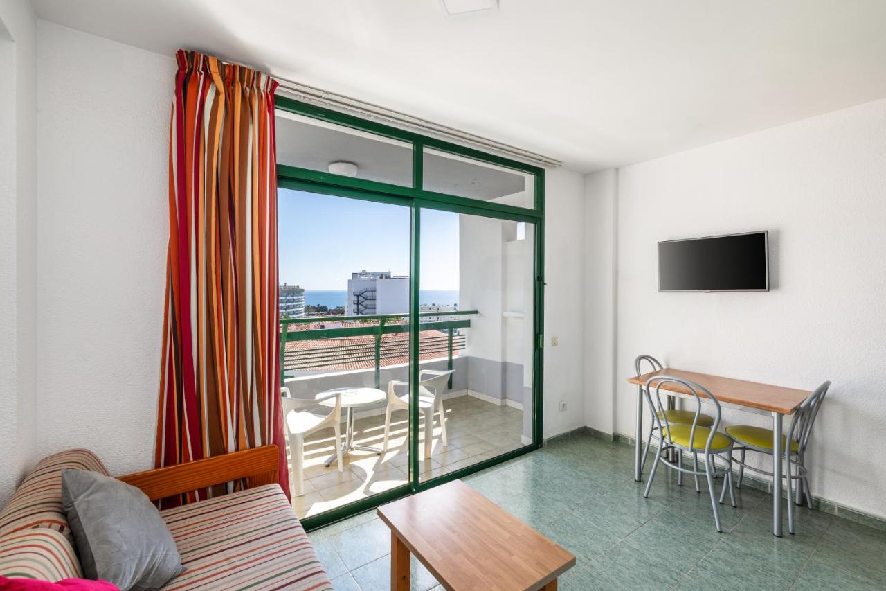 een woonkamer met een bank en een tafel bij RT-Green Park in Playa del Inglés
